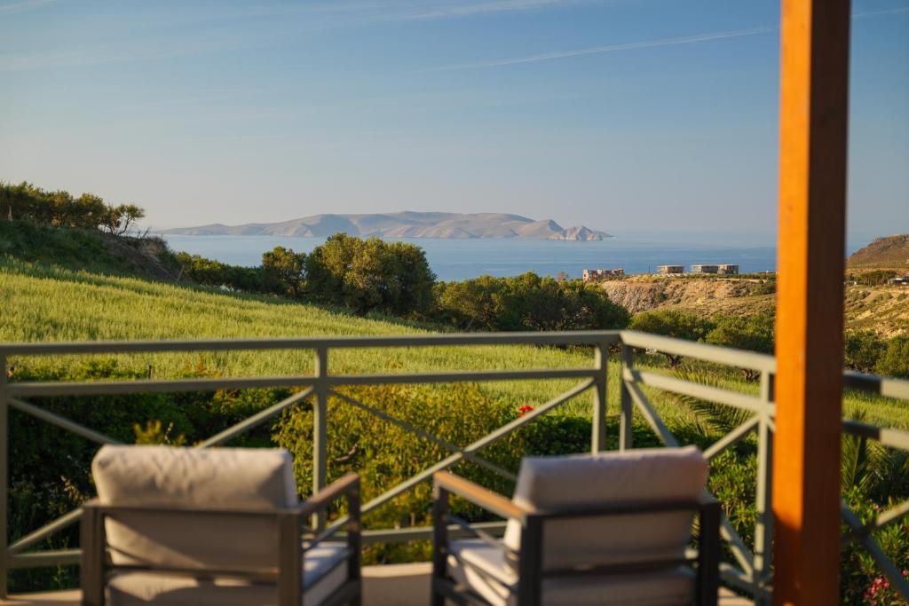 two chairs on a balcony with a view of the ocean at Dia View Retreat in Elaía