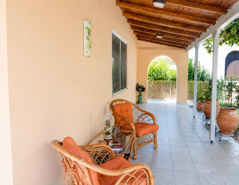 a porch with chairs and a table and a ceiling at Vicky's Sweet Home - Seaside Retreat in Evia in Agia Anna