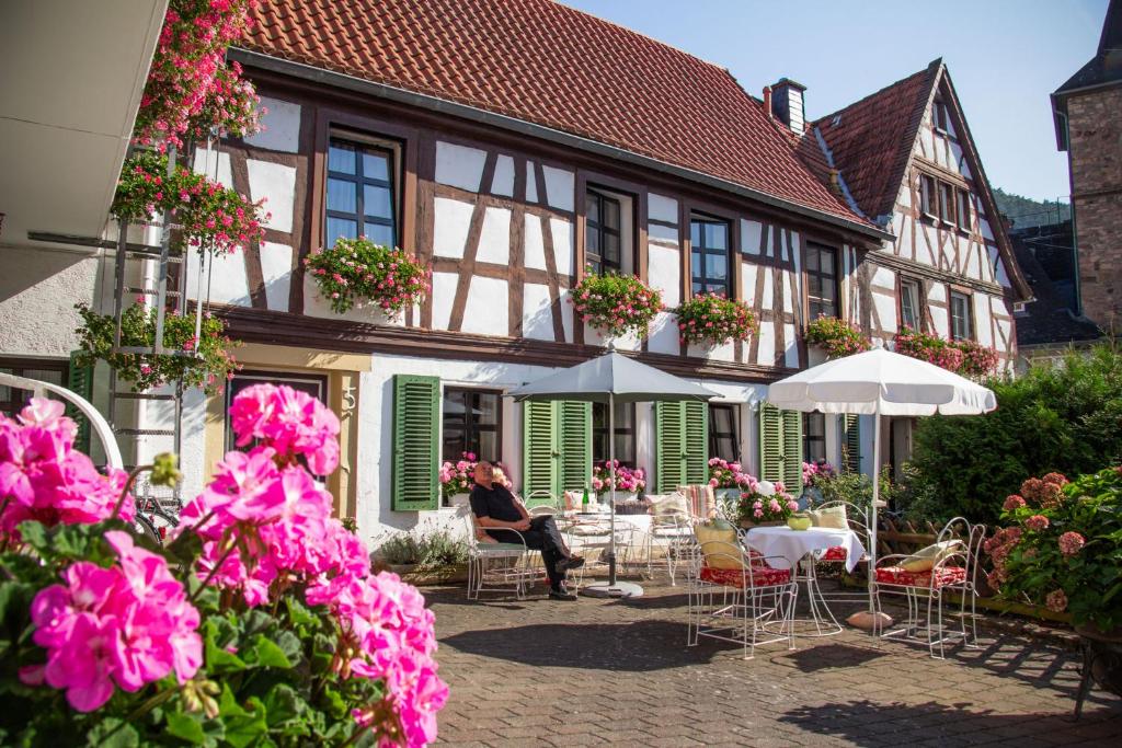 a woman sitting at a table in front of a building at Gästehaus Urschel in Bad Kreuznach