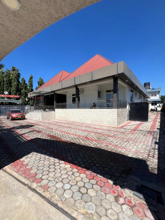 a building with a red roof and a road at Golden Tours Hotel in Dodoma