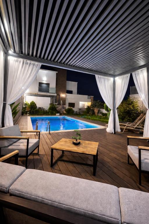 a living room with a couch and a pool at Villa luxueuse in Tipaza
