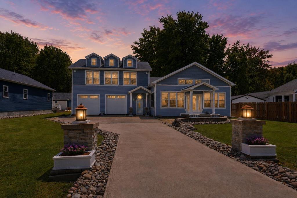 a blue house with lights on a driveway at Lake Rd E- Geneva in Geneva