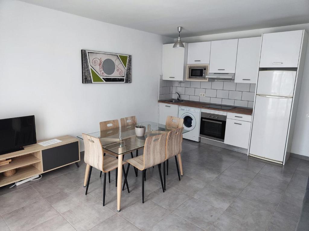 a kitchen with a table and chairs and a refrigerator at RealRent Costa Teguise Beach in Costa Teguise
