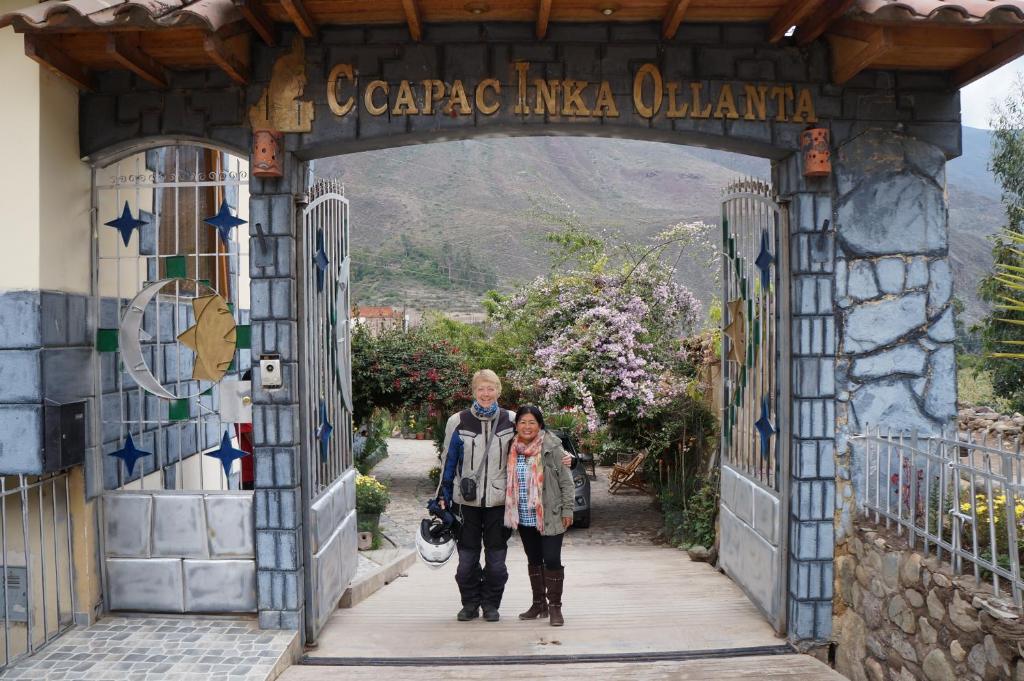 Un uomo e una donna che camminano attraverso un arco di Ccapac Inka Ollanta a Ollantaytambo
