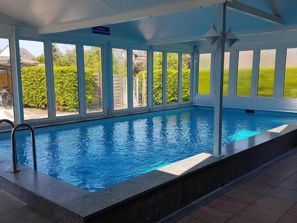 a large indoor swimming pool with blue water at Wattliebe Burhave in Burhave