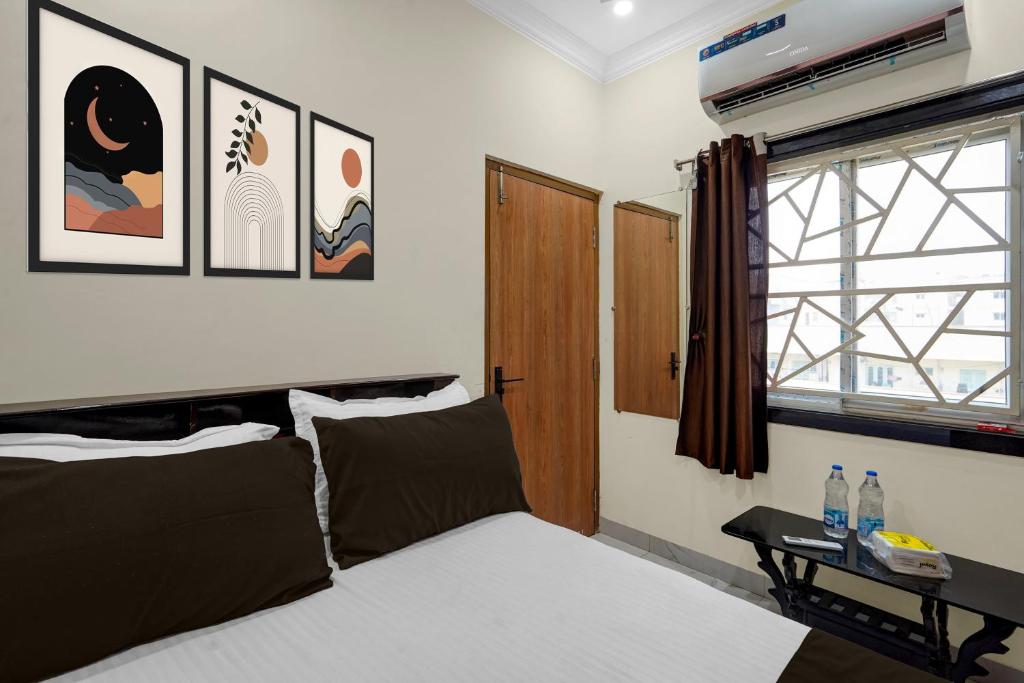 a bedroom with a bed and a window at Hotel O The Royal Guest Rooms in Vijayawāda