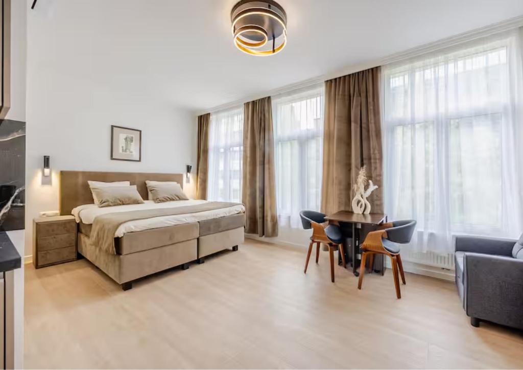 a bedroom with a bed and a table and chairs at GemStay Antwerp in Antwerp