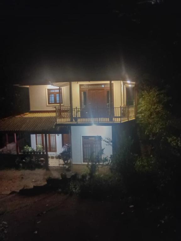 a house at night with a balcony on it at Trailside Homestay in Badulla