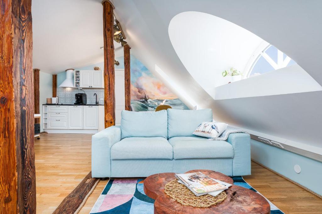 a living room with a blue couch and a table at Rüütli Residents in Pärnu