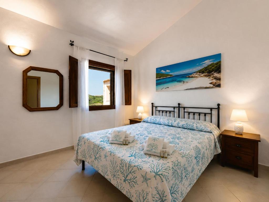 a bedroom with a bed and a mirror and a window at Piazzetta Dei Pini Two Bedroom Apartment 100 m from the Beach in Baja Sardinia
