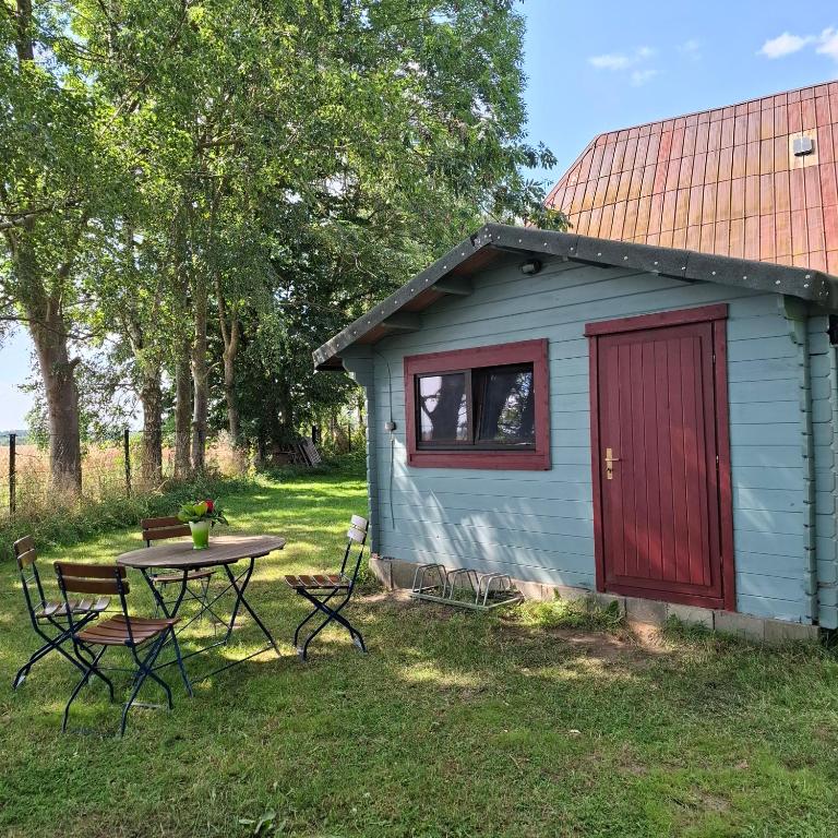 a small shed with a table and chairs in a yard at Casabandow in Schwaan