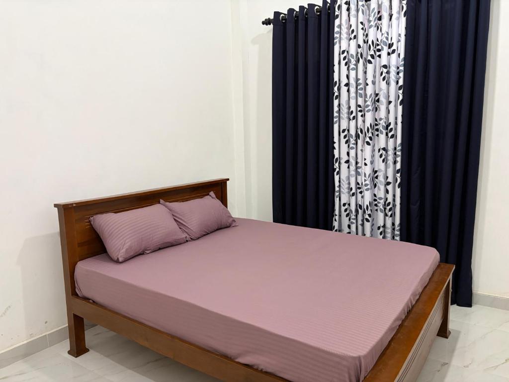 a bedroom with a bed with purple sheets at Yala Dream Guest House in Tissamaharama