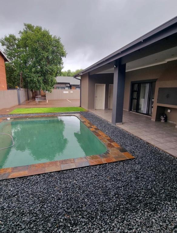 a pool of water in front of a building at Grey Corner Guesthouse in Postmasburg