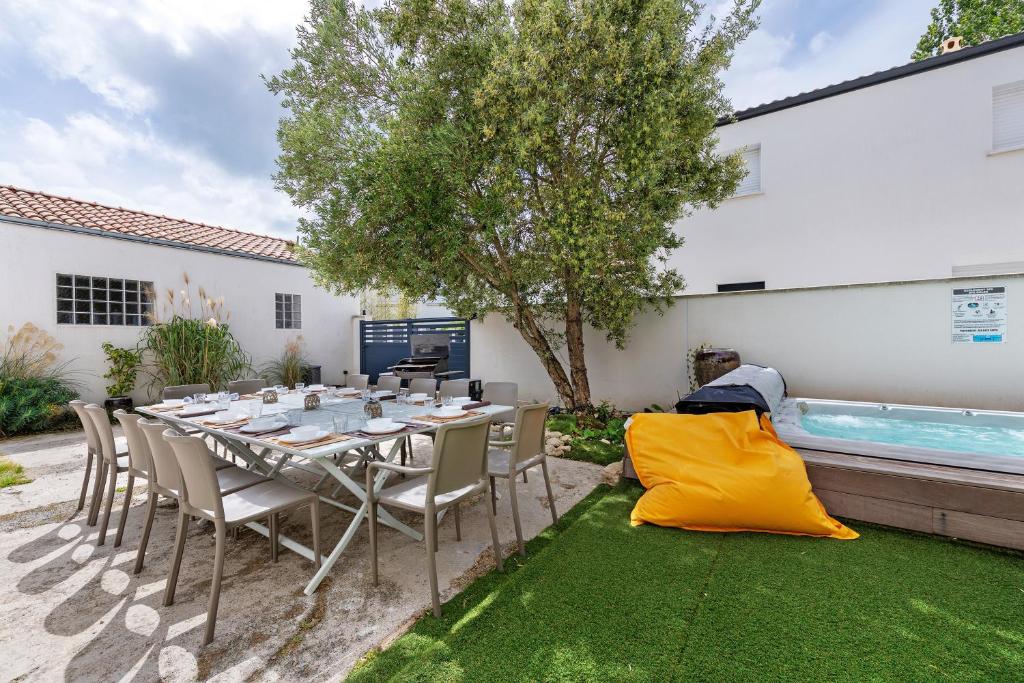 a dining table and chairs in a backyard with a pool at Villa Alekatele in La Tranche-sur-Mer