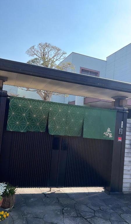 a building with a green banner over the front of it at 麻心家azamiya in Nagao