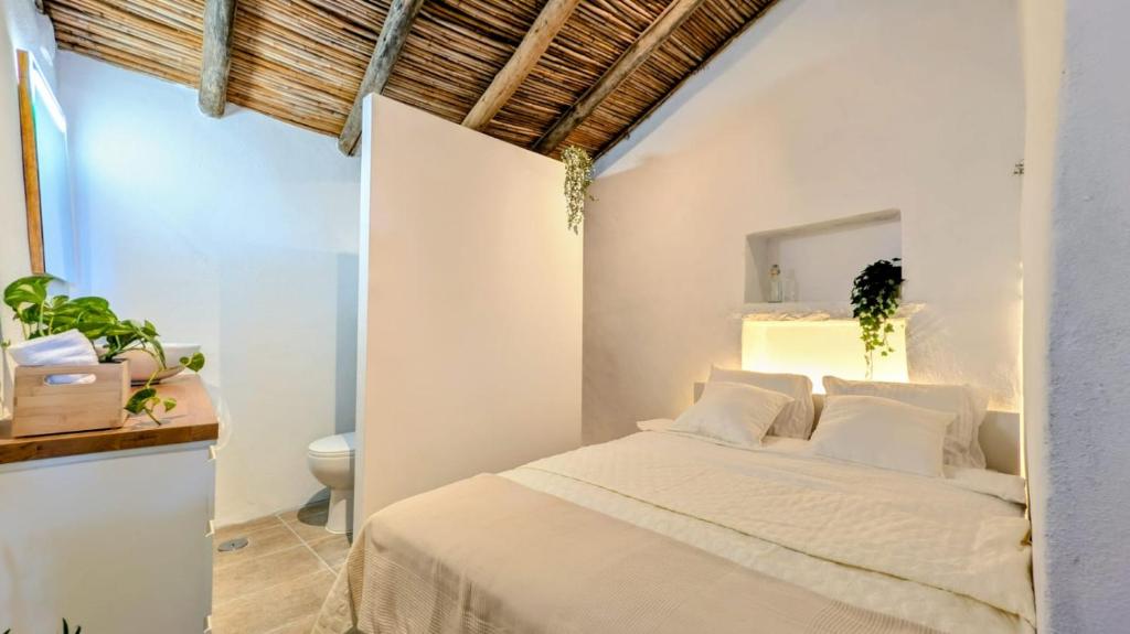 a white bedroom with a bed and a toilet at Casa Nossa in Azinhal