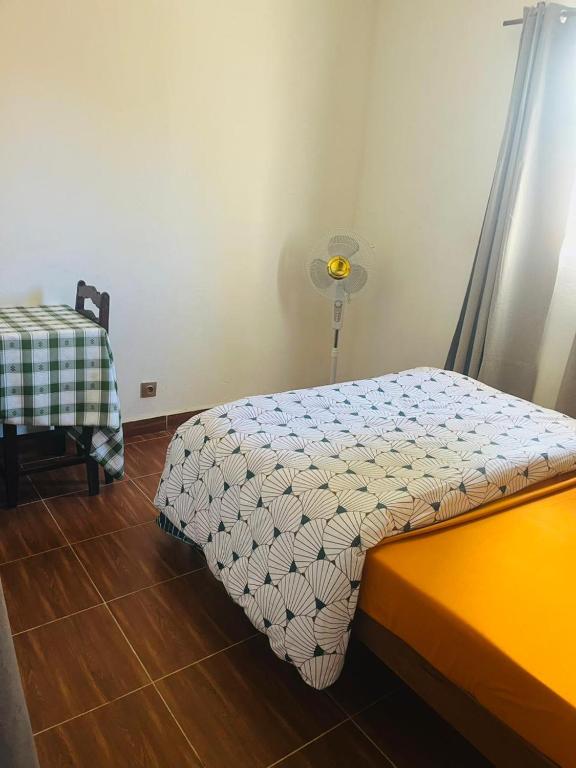 a small bedroom with a bed and a table at Chez Pauline in Sainte Marie