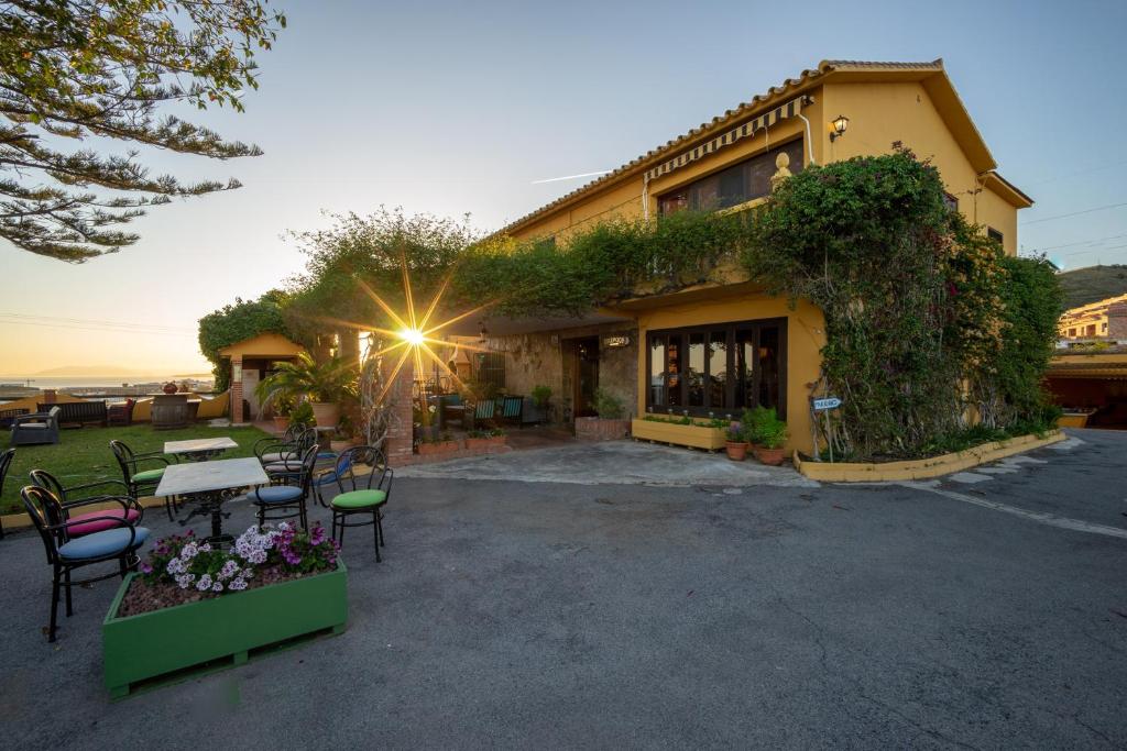a building with tables and chairs in front of it at Cortijo Amaya in Torrox Costa