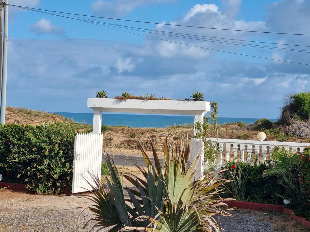 a white fence with a view of the ocean at Plage El Haouzia in El Jadida
