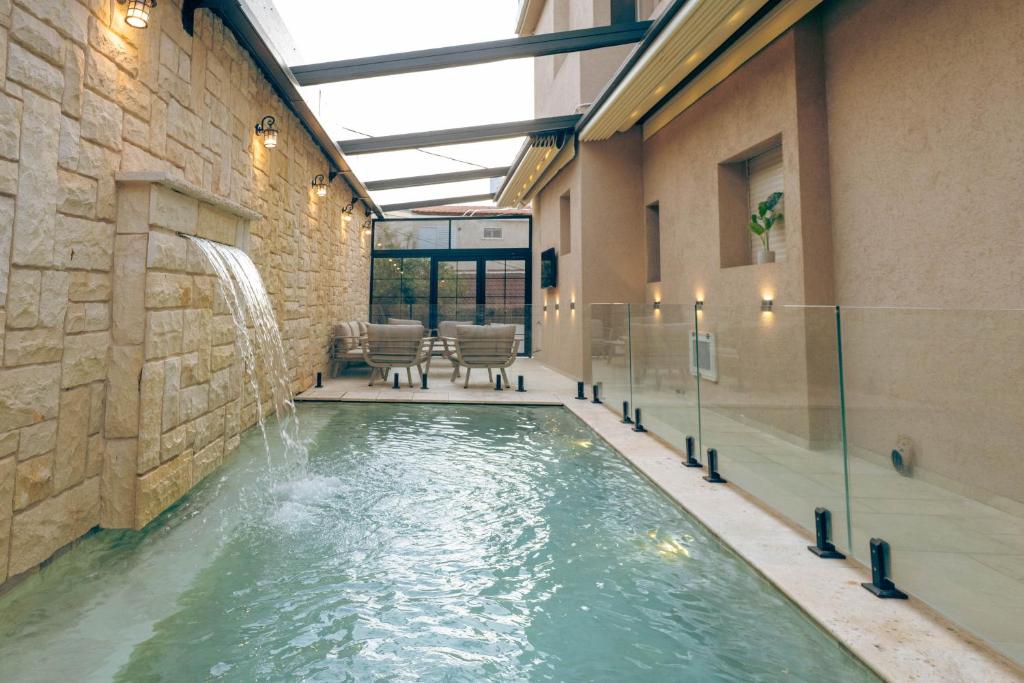 a indoor swimming pool with a waterfall in a building at Villa Lausanne - View in Dāliyat el Karmil