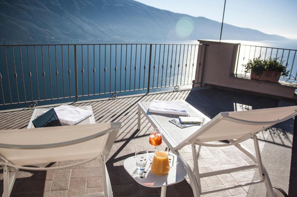 a balcony with two chairs and a table on a roof at Locanda Al Castelletto in Tremosine Sul Garda
