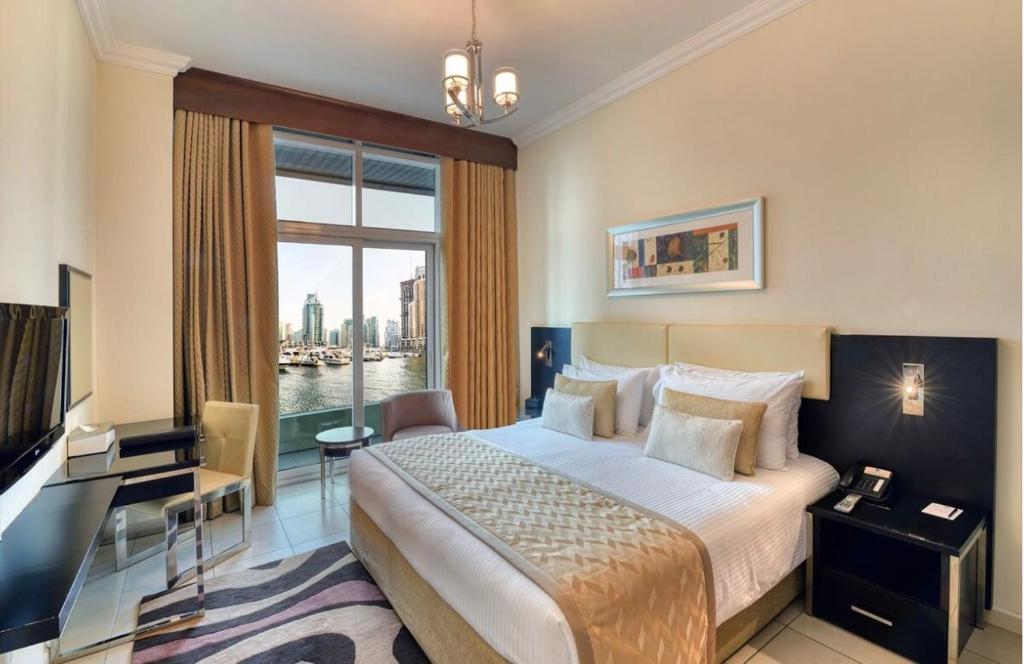 a hotel room with a bed and a large window at Hotel Vasudha Inn-Near International Airport Delhi in New Delhi