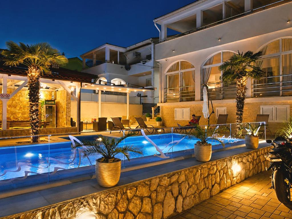 a villa with a swimming pool at night at Apartments Sun Dance 2 with heated Pool in Novalja