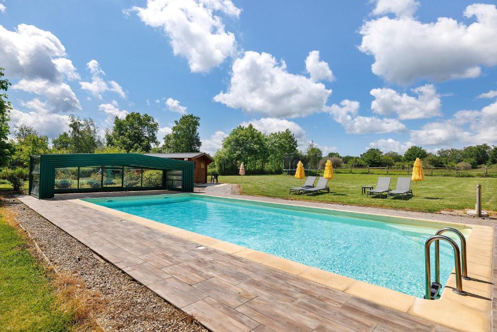a swimming pool with a gazebo next to a field at Les Malvaux - Chambres d'hôtes in Huriel