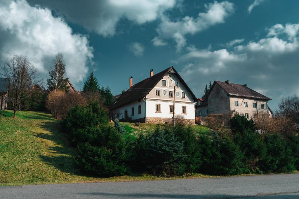 an old white house on a hill with trees at Apartmány Chalupa u Floriánka in Dolní Morava