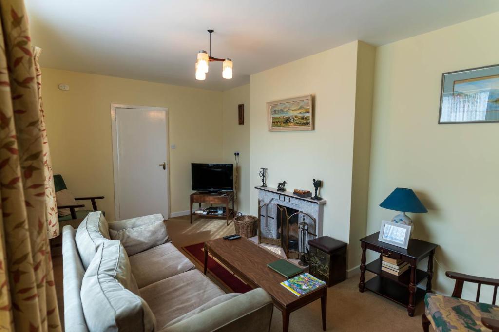a living room with a couch and a fireplace at Sneem Townhouse in Sneem
