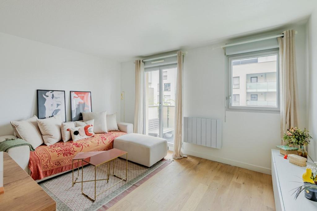 a white living room with a bed and a couch at Le Cocon d'Achères in Achères