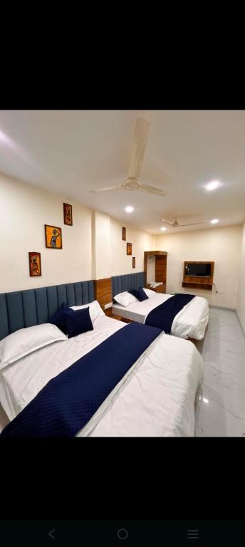 a room with three beds and a tv in it at Hotel metro inn in Bhopal
