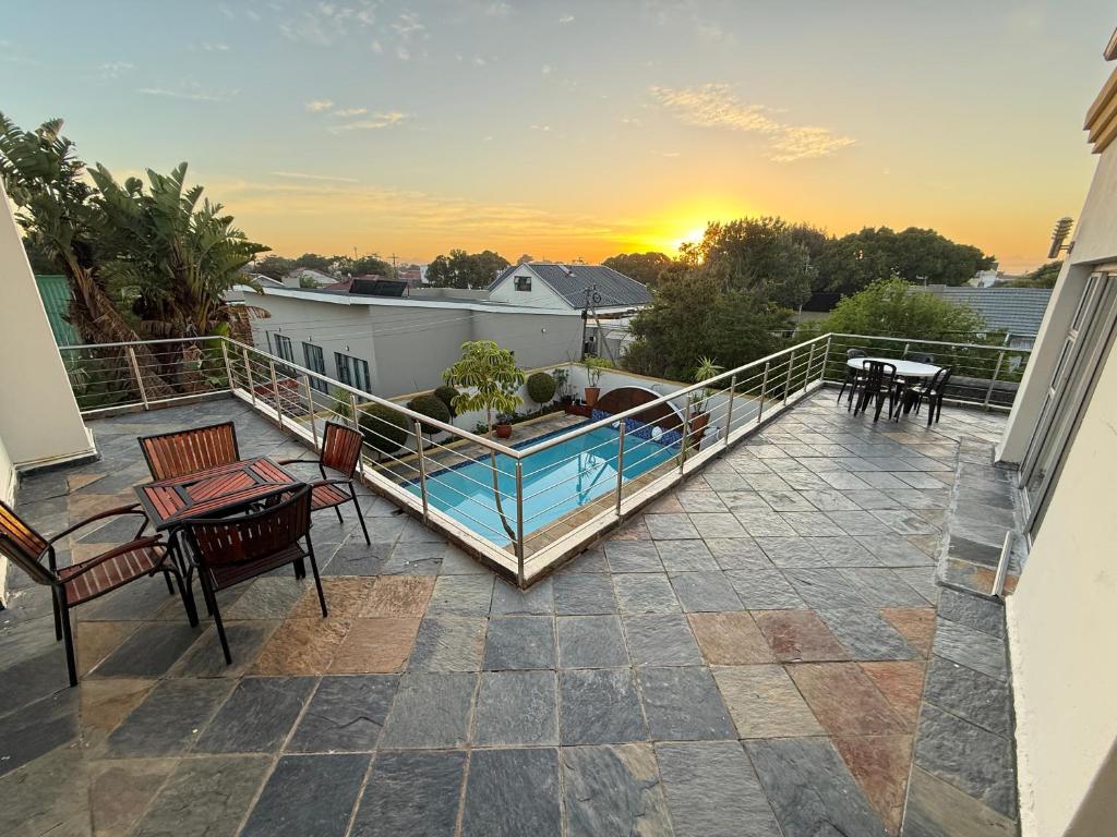 a balcony with a swimming pool on a house at Golden Feathers Lodge in Cape Town