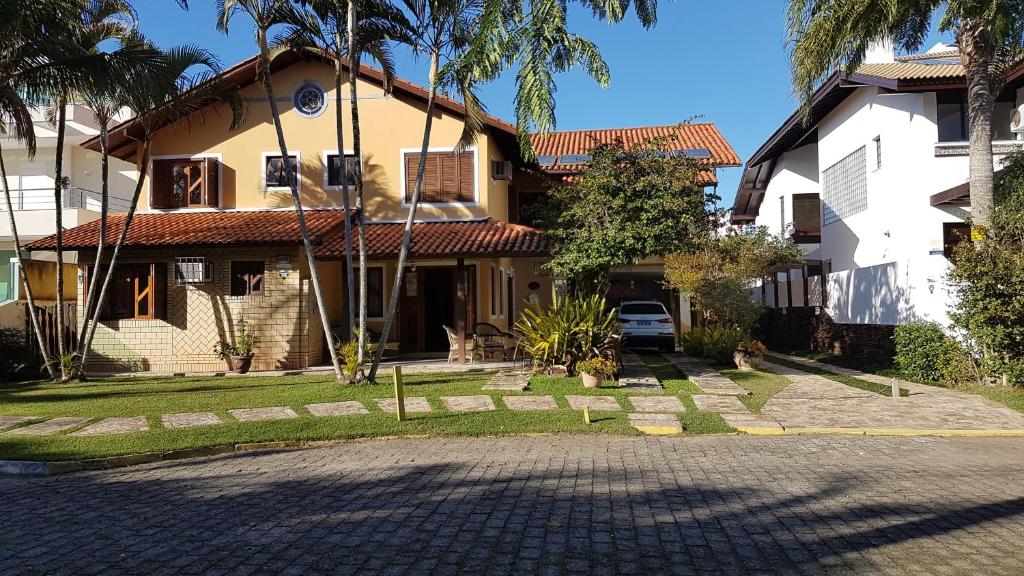 una casa con un coche aparcado delante de ella en Jurerê B&B, en Florianópolis