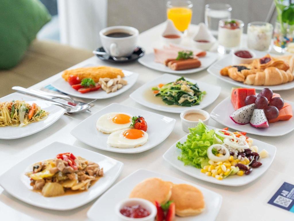 A breakfast spread with eggs, fruit, salads, pastries and hot dishes.