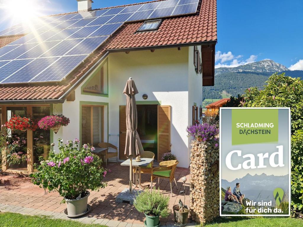 a house with solar panels on the roof at Appartement BERGTRÄUME in Haus im Ennstal