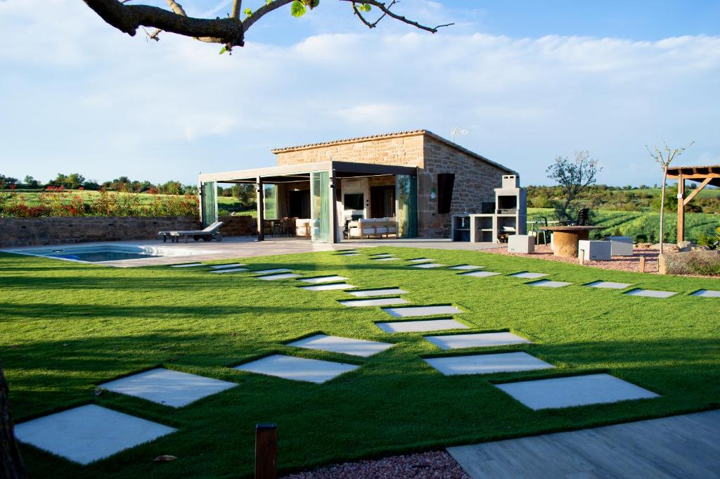 a lawn with stepping stones in front of a house at Natura-Resort Les Pletes in Palouet