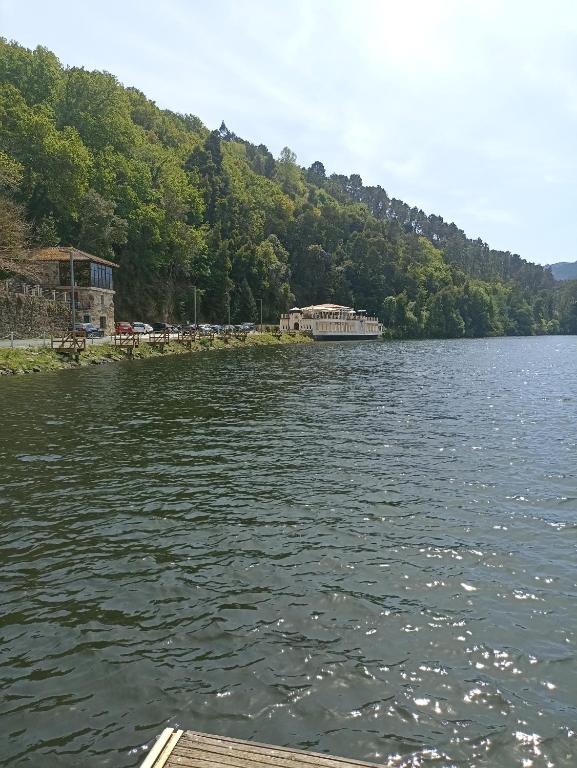 a view of a lake with a boat in the water at Casa rural Mirador, Balneario Histórico de Cortegada in Cortegada