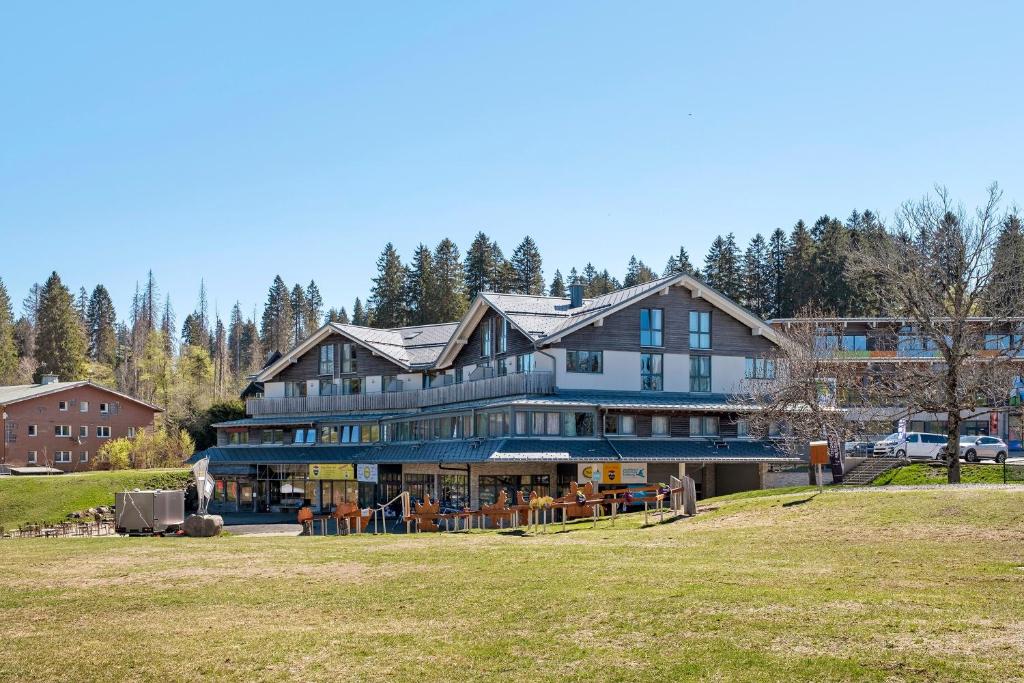 a large house on a hill with trees in the background at Wohnung direkt an der Skipiste in Feldberg