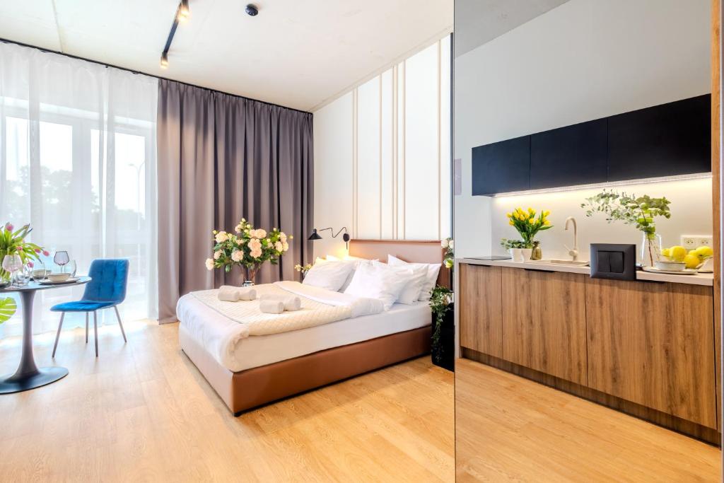 a hotel room with a bed and a table and a kitchen at ApartHotel S8 - Apartamenty Wrocław in Wrocław