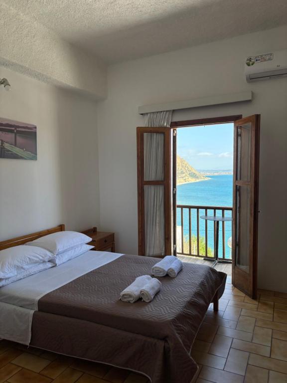 a bedroom with a bed with a view of the ocean at Pasiphae - Rooms for rent in Agia Galini