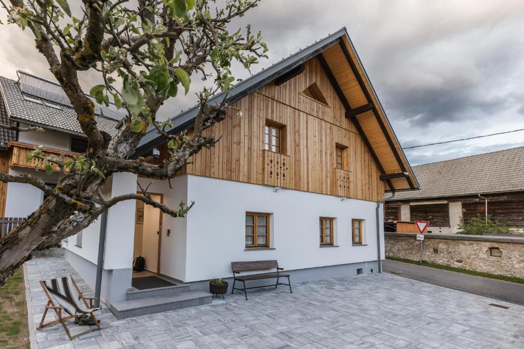 a house with a wooden roof and a courtyard at Alpine HOUSE 77 in Kranjska Gora