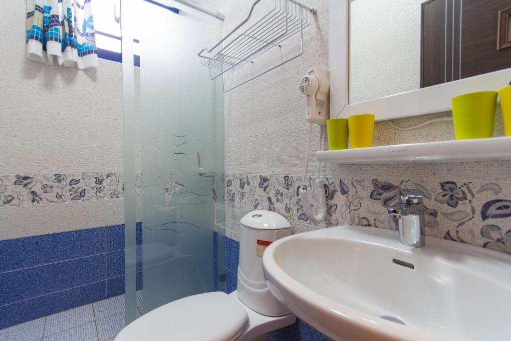 a bathroom with a sink and a toilet and a shower at Greek Wonderland B&amp;B in Hualien City