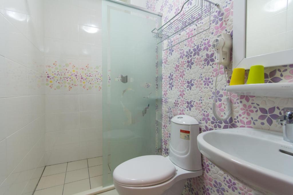 a bathroom with a shower and a toilet and a sink at Greek Wonderland B&amp;B in Hualien City