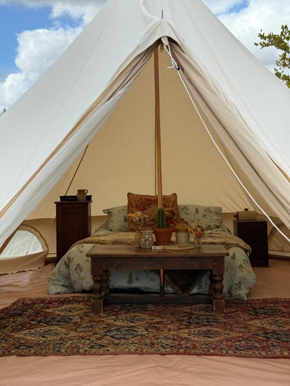 a bedroom with a tent with a bed and a table at Apuldram Roses in Appledram