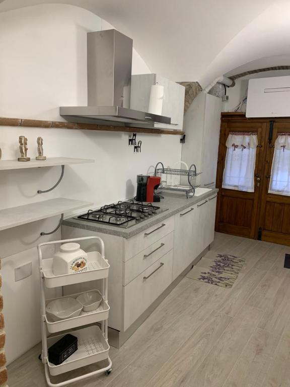 a kitchen with white cabinets and a stove top oven at Casa Paola in Spello