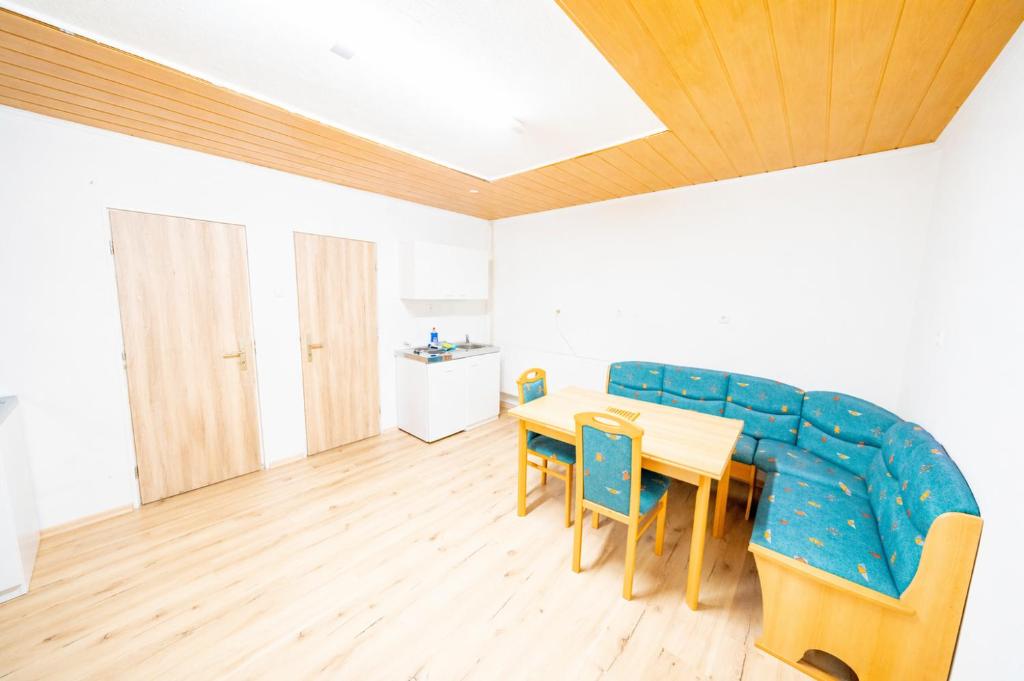 ein Esszimmer mit einem Tisch und einem blauen Sofa in der Unterkunft Große Monteurunterkunft Wulzeshofen in Wulzeshofen