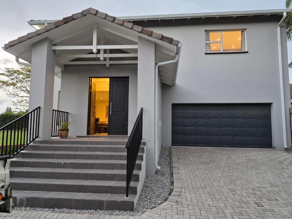 a white house with a black garage at Crocus Corner - Kyalami in Kyalami