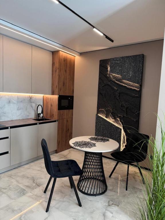 a kitchen with a table and two chairs in a room at CENTRAL Park in Vinnytsya