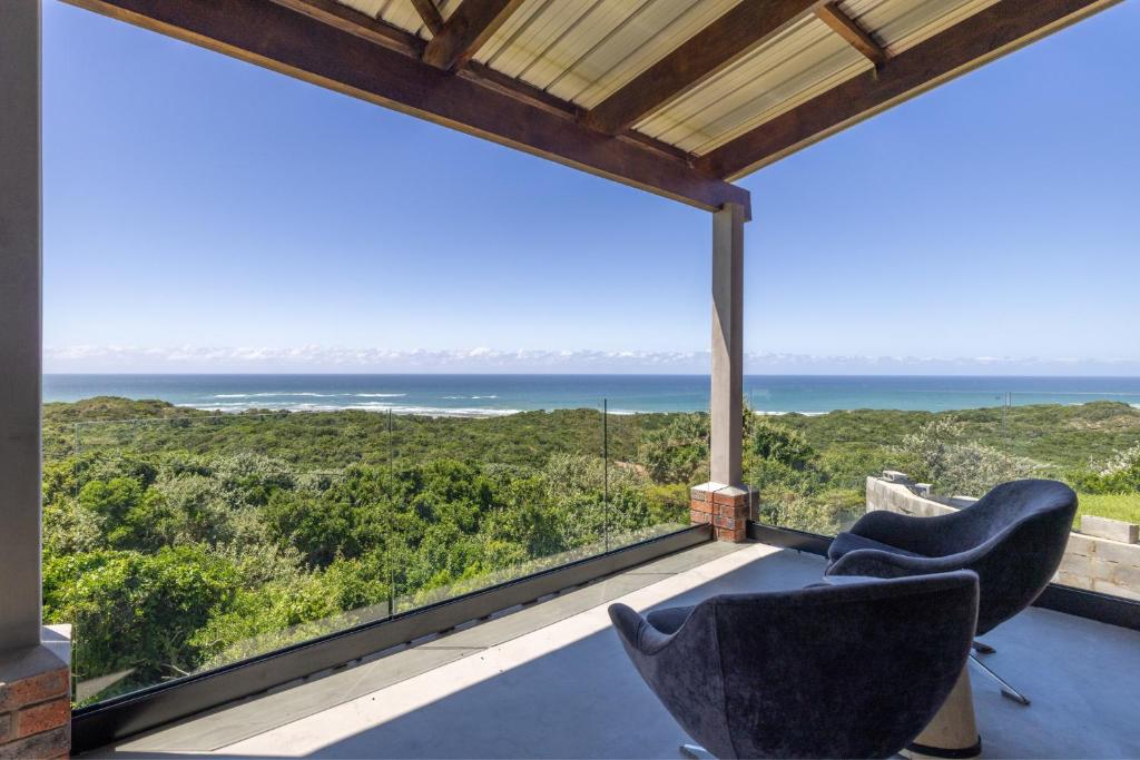 a view of the ocean from the balcony of a house at Begha 180 Beach House in Begha Mouth